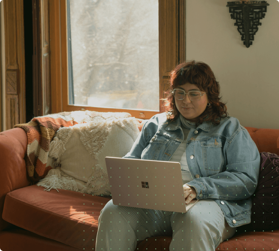 A woman on a couch with a laptop