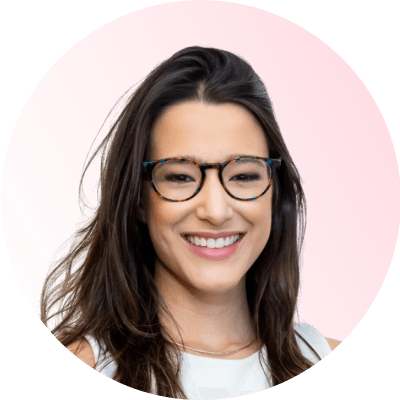 Circle-shaped professional headshot photo of Nicole Barra Conde smiling in a pink background